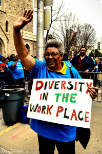 A woman holds a sign calling for diversity in the workplace to include individuals with disabilities who have historically faced many barriers to finding meaningful employment.