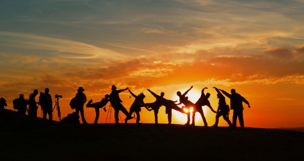 People posing in front of sunset