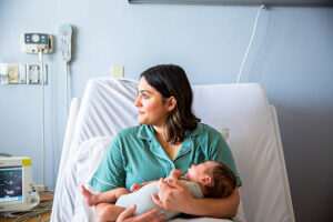 A mother sitting with her newborn baby
